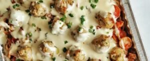 Fragrant meatballs simmering in a creamy coconut broth with garnishes.